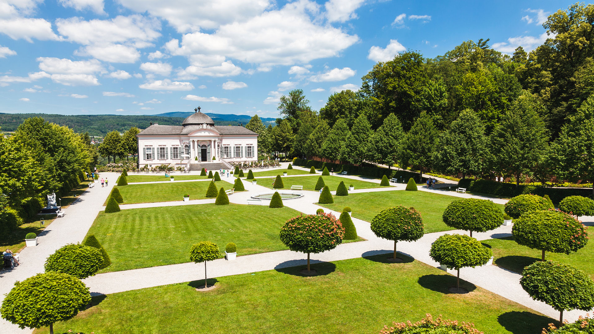 Baroque garden pavilion with clipped trees and formal lawns